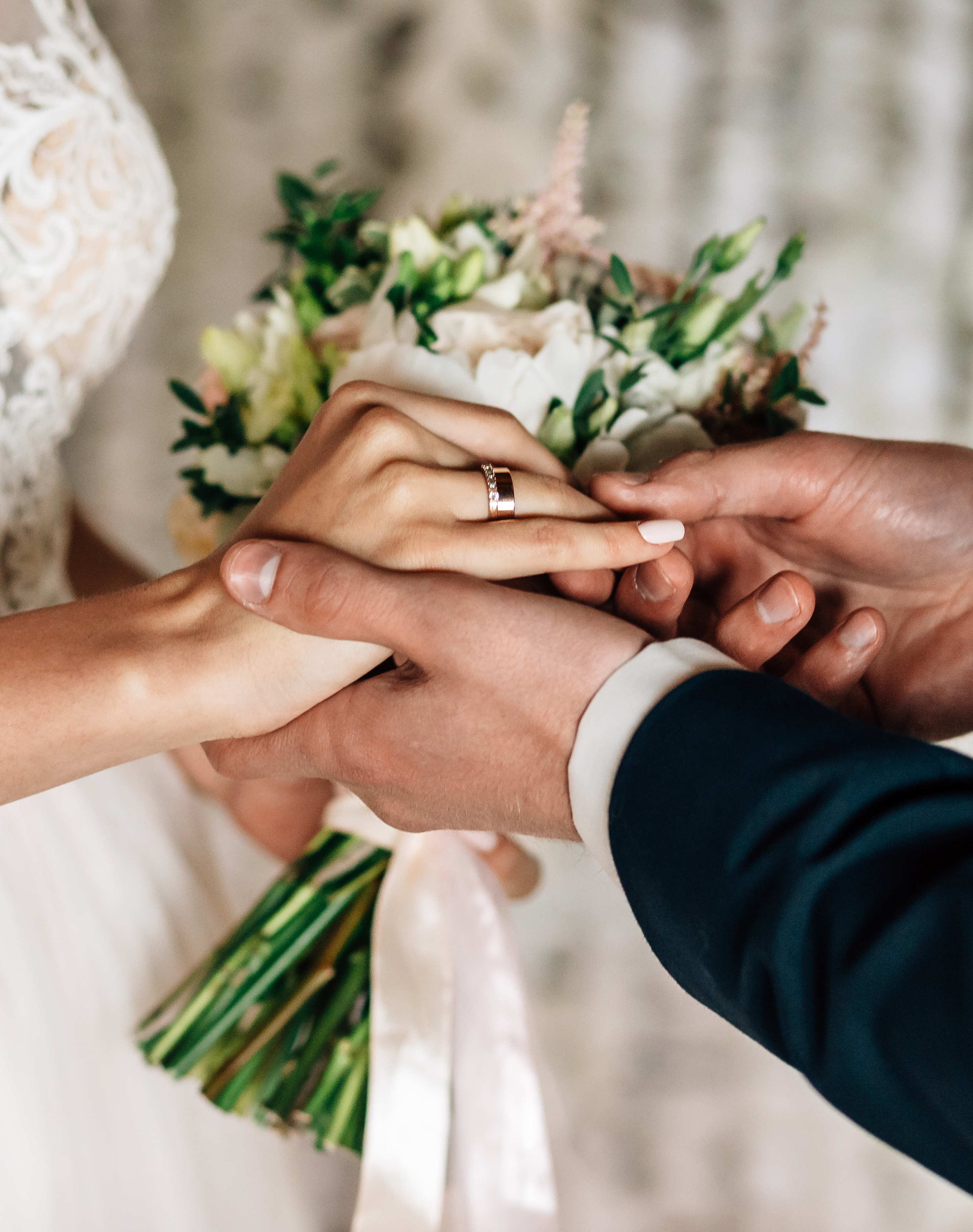 Close-up of couple holding hands during a personalized wedding ceremony.